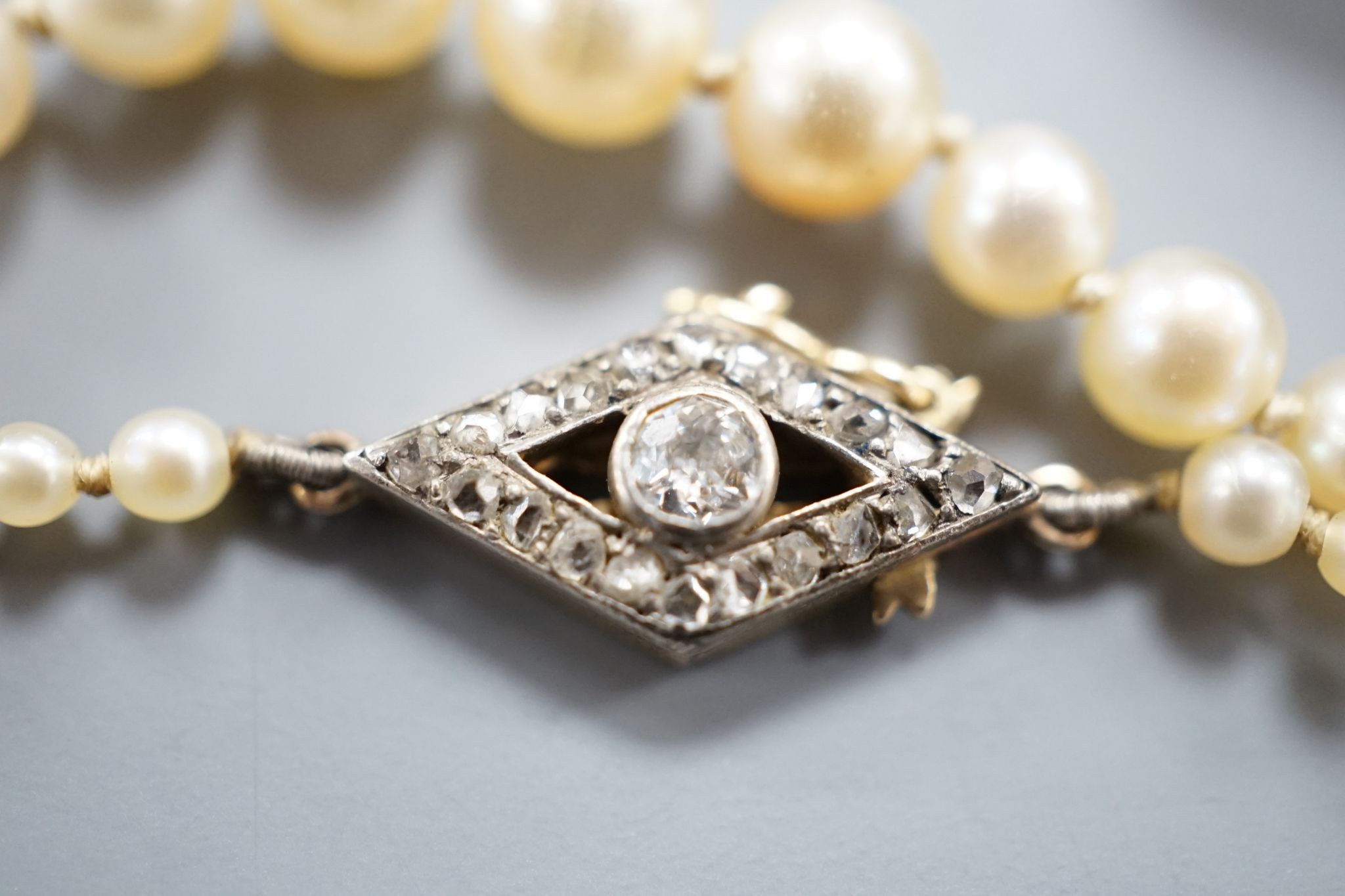 A single strand graduated seed pearl necklace, with yellow metal and diamond set clasp 42cm and a cased pair of similar Austro Hungarian ear clips.